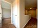 Bright hallway with a view into a bedroom, showcasing neutral walls and wood-look flooring at 7147 Henderson Valley Ln, Charlotte, NC 28269