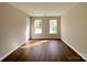 Living room featuring hardwood floors, neutral walls, and windows with outside view at 7147 Henderson Valley Ln, Charlotte, NC 28269