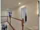 Hallway with white walls, carpet flooring, a white railing and access to multiple rooms at 848 Wingthorn Rose Dr, Gastonia, NC 28056
