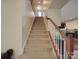 View of a carpeted staircase with a light-colored wall and white trim and rail at 848 Wingthorn Rose Dr, Gastonia, NC 28056