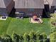 Aerial view of a home with a brick patio featuring an outdoor dining area, fire pit, and lush lawn at 9622 Harvest Pond Nw Dr, Concord, NC 28027