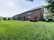 Expansive backyard with a brick patio, outdoor dining area, fire pit, and well-maintained lawn at 9622 Harvest Pond Nw Dr, Concord, NC 28027