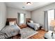 Bright bedroom with two twin beds, hardwood floors, natural light, and simple elegant decor at 9622 Harvest Pond Nw Dr, Concord, NC 28027