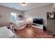Cozy bedroom featuring hardwood floors, a white metal bed frame, and bright natural light at 9622 Harvest Pond Nw Dr, Concord, NC 28027