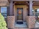 Inviting front entryway with a decorative wreath, brick pillars, and a dark wood door at 9622 Harvest Pond Nw Dr, Concord, NC 28027