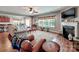 Bright living room with hardwood floors, ceiling fan and large windows, leading to a modern kitchen at 9622 Harvest Pond Nw Dr, Concord, NC 28027