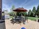 Outdoor patio featuring brick pavers, umbrella-covered dining set, and grill, perfect for entertaining at 9622 Harvest Pond Nw Dr, Concord, NC 28027