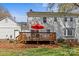 Outdoor living on a spacious wood back deck featuring an umbrella and seating in a lush backyard at 9637 Stoney Hill Ln, Charlotte, NC 28277