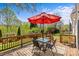 Outdoor back deck with ample seating under a shade umbrella overlooking the beautiful backyard at 9637 Stoney Hill Ln, Charlotte, NC 28277