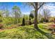 Lush backyard featuring a well-maintained lawn, established trees, and a decorative pergola at 9637 Stoney Hill Ln, Charlotte, NC 28277