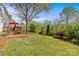 Spacious backyard with lush lawn, mature trees, and a charming wooden deck area at 9637 Stoney Hill Ln, Charlotte, NC 28277