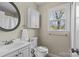 This bathroom features a modern vanity, oval mirror, and ample natural light at 9637 Stoney Hill Ln, Charlotte, NC 28277