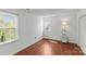 A clean bedroom featuring hardwood floors and two bright windows to let in natural light at 9637 Stoney Hill Ln, Charlotte, NC 28277