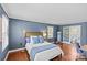 Comfortable bedroom featuring hardwood floors, a queen bed with a blue throw, and access to an ensuite bathroom at 9637 Stoney Hill Ln, Charlotte, NC 28277