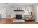 Charming fireplace with white brick, rustic mantel decor, and wood flooring creating a cozy focal point at 9637 Stoney Hill Ln, Charlotte, NC 28277
