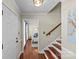 Inviting foyer with hardwood floors, a staircase with wooden rails, and a glimpse into a sunlit living space at 9637 Stoney Hill Ln, Charlotte, NC 28277