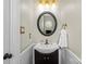 Stylish half bathroom with a modern sink, round mirror, and updated fixtures at 9637 Stoney Hill Ln, Charlotte, NC 28277