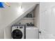 Efficient laundry room featuring a modern washer and dryer set with storage shelf at 9637 Stoney Hill Ln, Charlotte, NC 28277