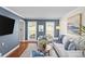 Cozy living room with stylish blue accents, wood floors, comfortable seating, and large windows for natural light at 9637 Stoney Hill Ln, Charlotte, NC 28277