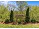 Close-up of a wooden pergola with climbing vines surrounded by mature trees and landscaping at 9637 Stoney Hill Ln, Charlotte, NC 28277