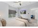 Cozy bedroom features a ceiling fan, tv, side window and entry view to a charming blue accent chair at 1117 Cedar Park Dr, Pineville, NC 28134