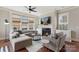 Cozy living room with plush sectional, fireplace, and large windows providing natural light at 1117 Cedar Park Dr, Pineville, NC 28134