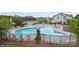 Community swimming pool area with lounge chairs, tables, and umbrellas for relaxation at 1117 Cedar Park Dr, Pineville, NC 28134