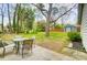 View of a backyard featuring a patio set, lawn, mature trees, and a storage shed at 1212 Robinhood Cir, Charlotte, NC 28227