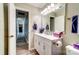 Bathroom featuring a white vanity with storage, a mirror with vanity lighting and a view down the hall at 1212 Robinhood Cir, Charlotte, NC 28227
