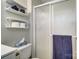 A bathroom featuring a sliding glass shower door and convenient shelving above the toilet at 1212 Robinhood Cir, Charlotte, NC 28227