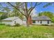Back exterior view showing the backyard, storage shed, and a brick chimney at 1212 Robinhood Cir, Charlotte, NC 28227