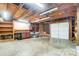 Unfinished garage with exposed wood framing, storage, and an overhead garage door at 1212 Robinhood Cir, Charlotte, NC 28227