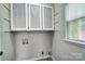 Bright laundry room featuring white cabinets with patterned fronts, and a window at 1212 Robinhood Cir, Charlotte, NC 28227