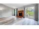 Bright living room with modern floors, a brick fireplace, and a sliding glass door to the backyard at 1212 Robinhood Cir, Charlotte, NC 28227