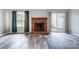 Cozy living room with modern flooring, a brick fireplace, and sliding glass doors to the patio at 1212 Robinhood Cir, Charlotte, NC 28227
