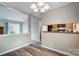 Open-concept living room showcasing wood floors, stylish lighting, and seamless flow into the kitchen at 1212 Robinhood Cir, Charlotte, NC 28227