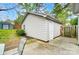 Side view of a detached outbuilding featuring vinyl siding, door, and concrete pad at 1212 Robinhood Cir, Charlotte, NC 28227