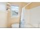 Bright bathroom featuring a shower with curtain, toilet, and a window for natural light at 14130 Misty Brook Ln, Charlotte, NC 28273