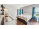 Well-lit bedroom featuring neutral decor, dark wood floors, and a comfortable bed at 14130 Misty Brook Ln, Charlotte, NC 28273