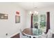 Cozy dining room with a round table, chandelier, and natural light streaming through the windows at 14130 Misty Brook Ln, Charlotte, NC 28273