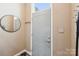 Welcoming entryway featuring a modern door, mirror, and convenient coat hooks for organization at 14130 Misty Brook Ln, Charlotte, NC 28273