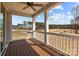 Back porch view with ceiling fan, white railing and columns, and beautiful wooded backdrop at 143 Mills Garden Rd, Statesville, NC 28625