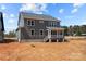 Exterior view of a two-story home featuring gray siding, a back porch, and a landscaped yard at 143 Mills Garden Rd, Statesville, NC 28625