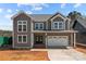 Charming two-story home featuring a two-car garage, a covered entry, and a modern gray color scheme at 143 Mills Garden Rd, Statesville, NC 28625