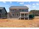 Exterior view of a two-story home featuring gray siding, a back porch, and a landscaped yard at 143 Mills Garden Rd, Statesville, NC 28625