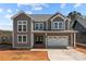 Charming two-story home with gray siding, white trim, covered entrance, and an attached two-car garage at 143 Mills Garden Rd, Statesville, NC 28625
