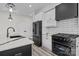 Modern kitchen with white cabinets, black appliances, stylish countertops and wood floors at 143 Mills Garden Rd, Statesville, NC 28625