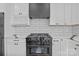 Close-up of a stainless steel range with subway tile backsplash and white cabinets in this stylish, modern kitchen at 143 Mills Garden Rd, Statesville, NC 28625