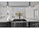 Modern kitchen featuring a stainless steel farmhouse sink, marble countertops, and pendant lighting at 143 Mills Garden Rd, Statesville, NC 28625