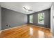 Spacious bedroom with hardwood floors, two windows, and a modern ceiling fan at 15001 Arrowgrass Way, Charlotte, NC 28278